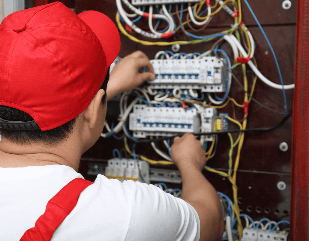 electrician replacing electrical breaker and wiring inside panel box